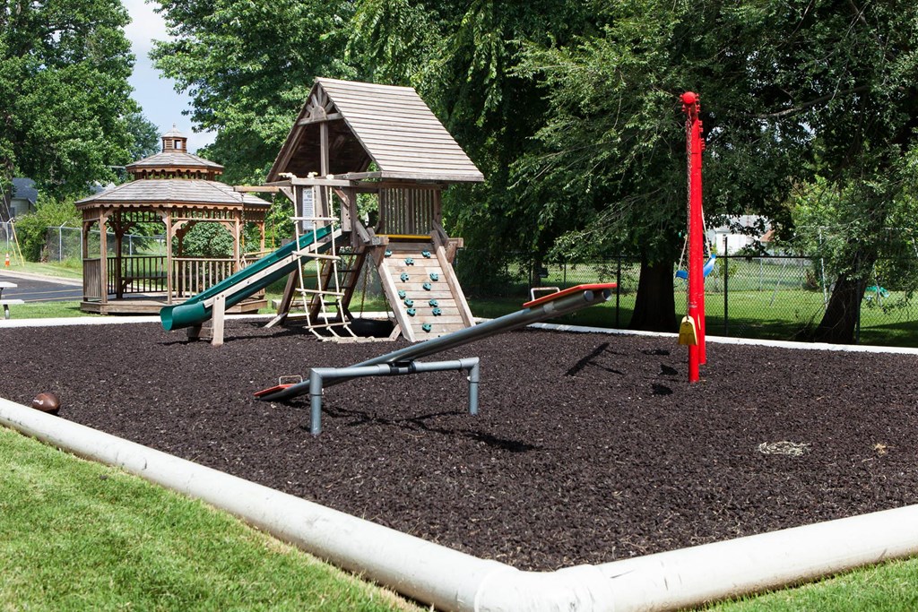 a playground with a swing set and a gazebo