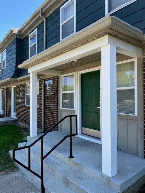 a house with a green door and black railing