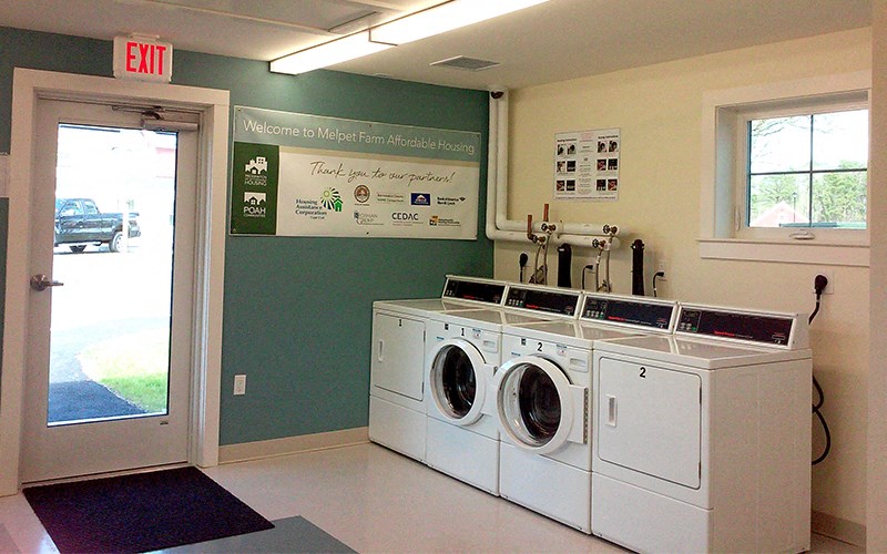 a laundry room with two washing machines and a door to a parking lot