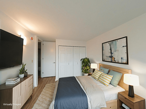 A bedroom with a bed, nightstand, and a television.