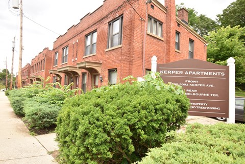 a sign for kepler apartments in front of a brick building