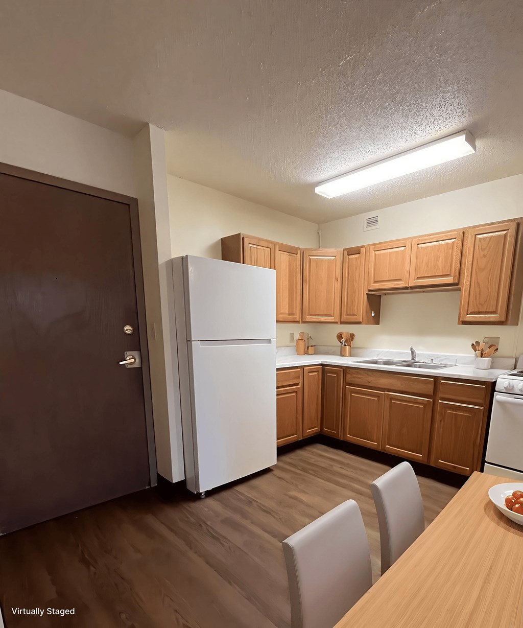 A kitchen with wooden cabinets and a white refrigerator.
