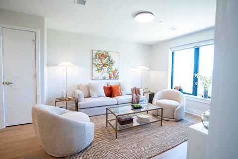 a living room with a couch and two chairs and a coffee table
