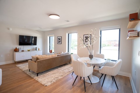 a living room with a couch table and chairs and a tv