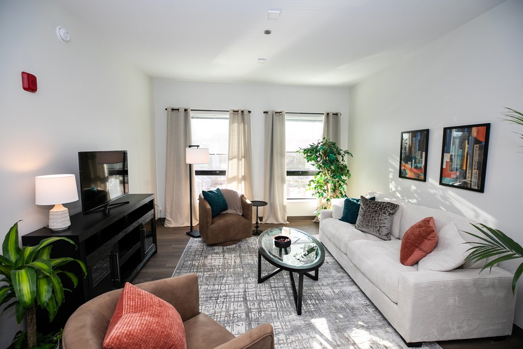 A living room with a white couch, a brown armchair, and a coffee table.