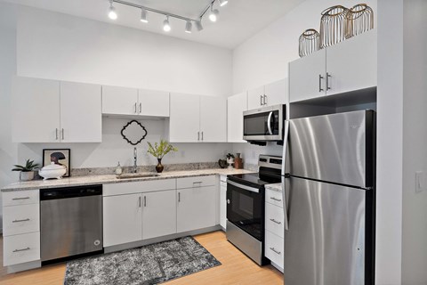 a kitchen with white cabinets and stainless steel appliances