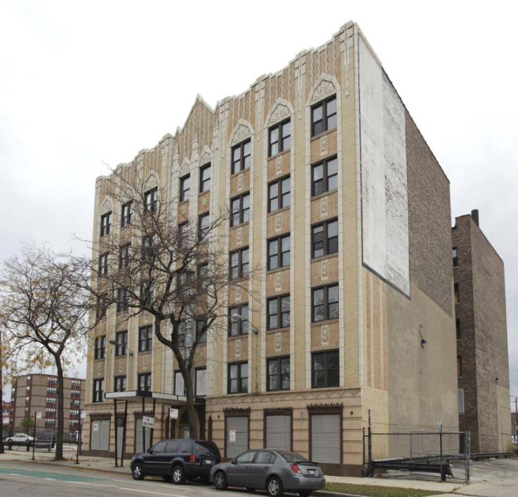a large brick building with cars parked in front of it