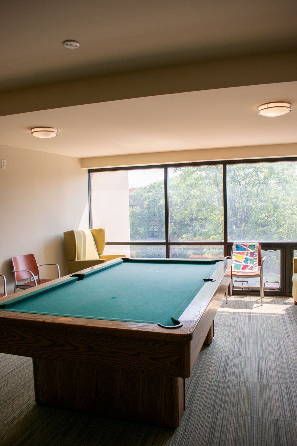 a pool table sits in the middle of a room with a large window