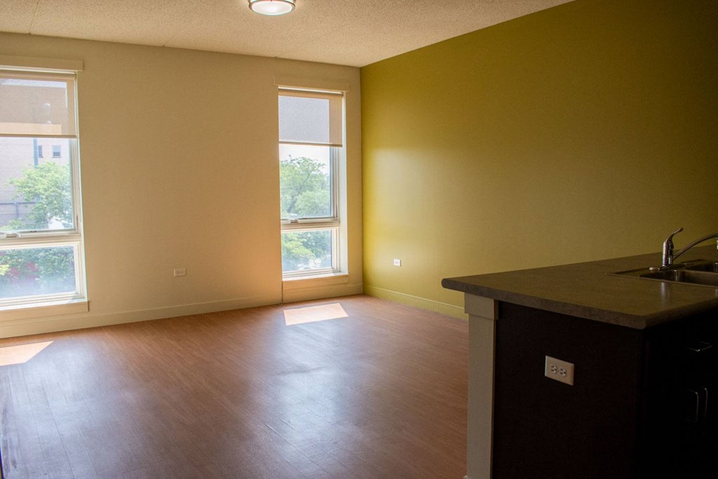 an empty living room with a sink and window