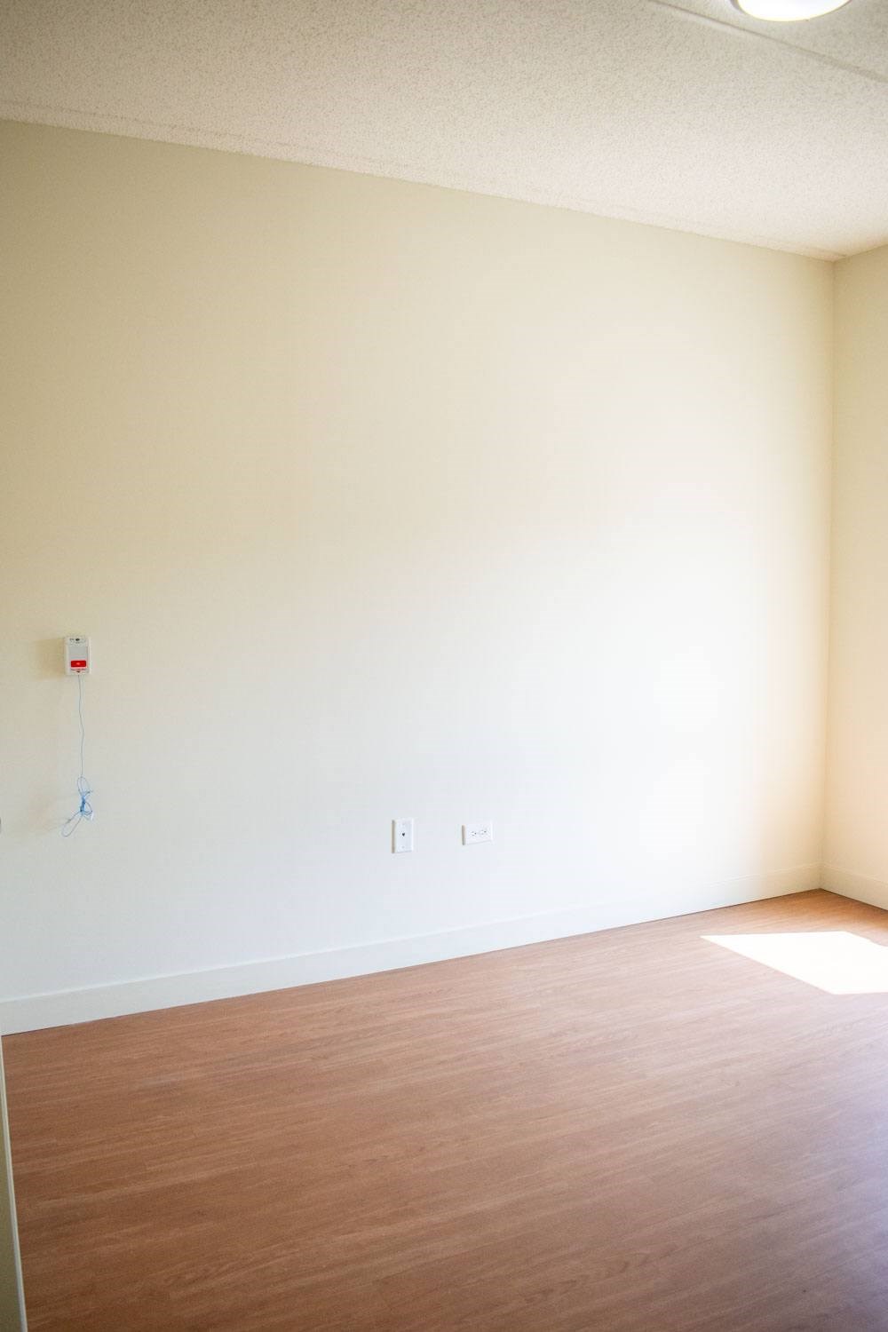 an empty room with white walls and a wooden floor
