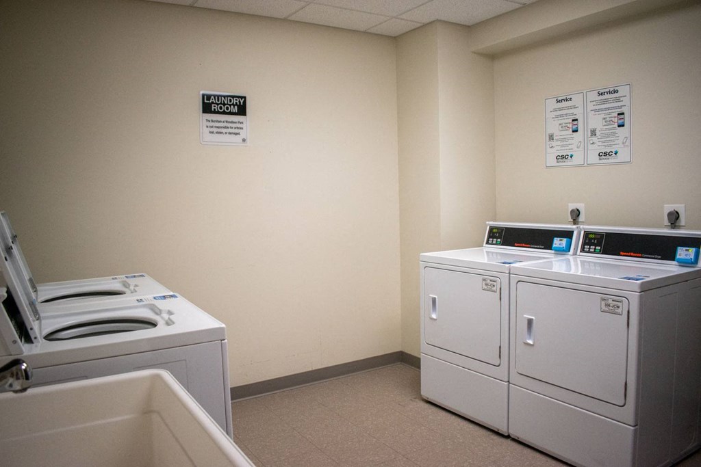 a laundry room with four washers and two dryers