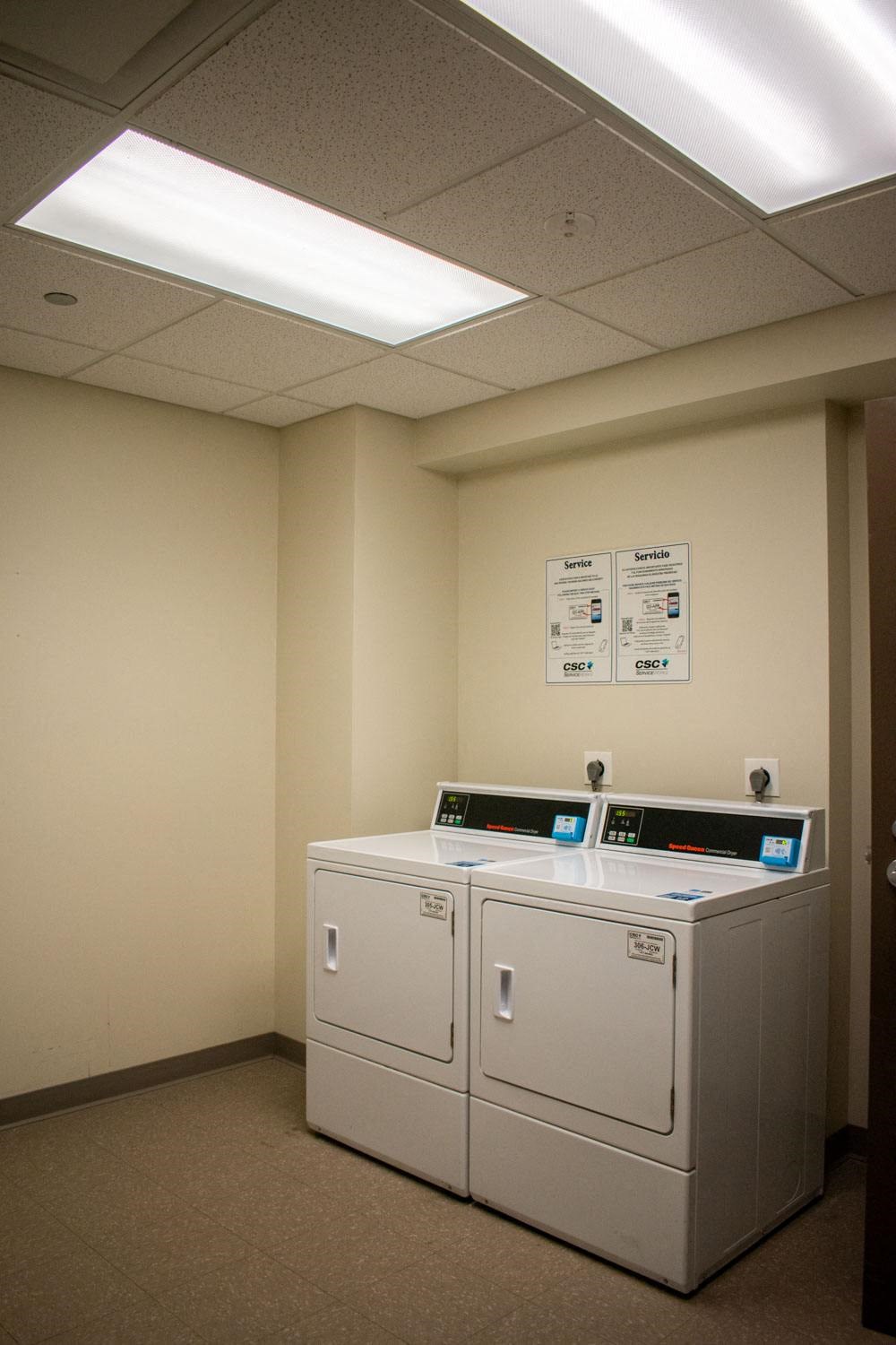 a room with two washers and two dryers