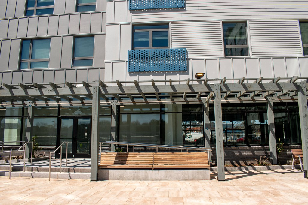 the front of a building with a wooden bench in front