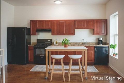 A kitchen with wooden cabinets and a black refrigerator.