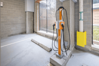 A concrete room with a yellow box and a charging station.