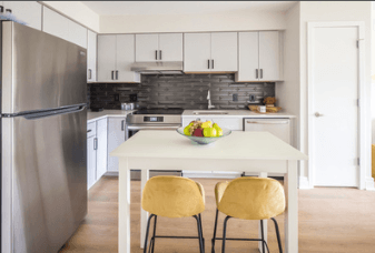 A kitchen with a table and chairs and a refrigerator.