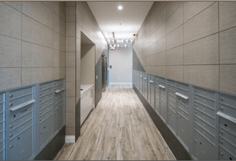 A long hallway with wood floors and grey walls.