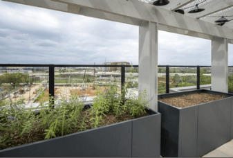 A balcony with grey planters and a view of a construction site.