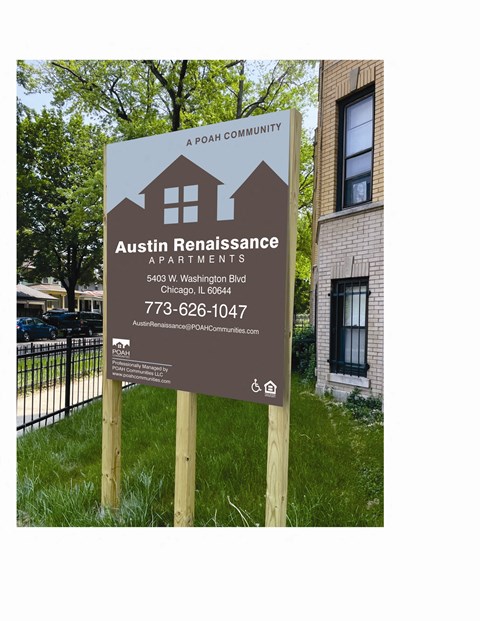 A sign for Austin Renaissance Apartments is displayed in front of a building.