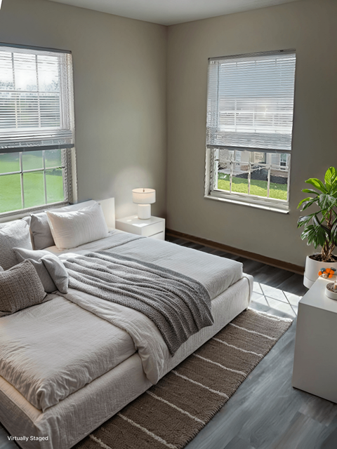 A bedroom with a large bed and a potted plant.
