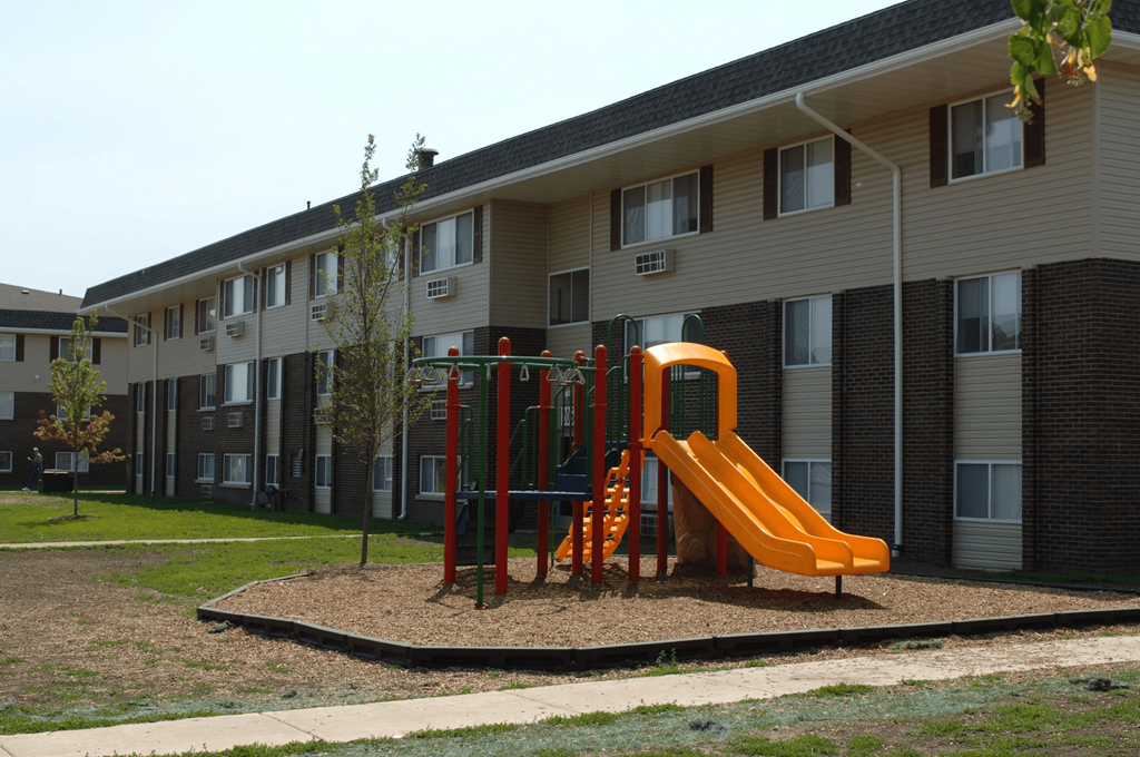 an orange playground in front of an apartment building