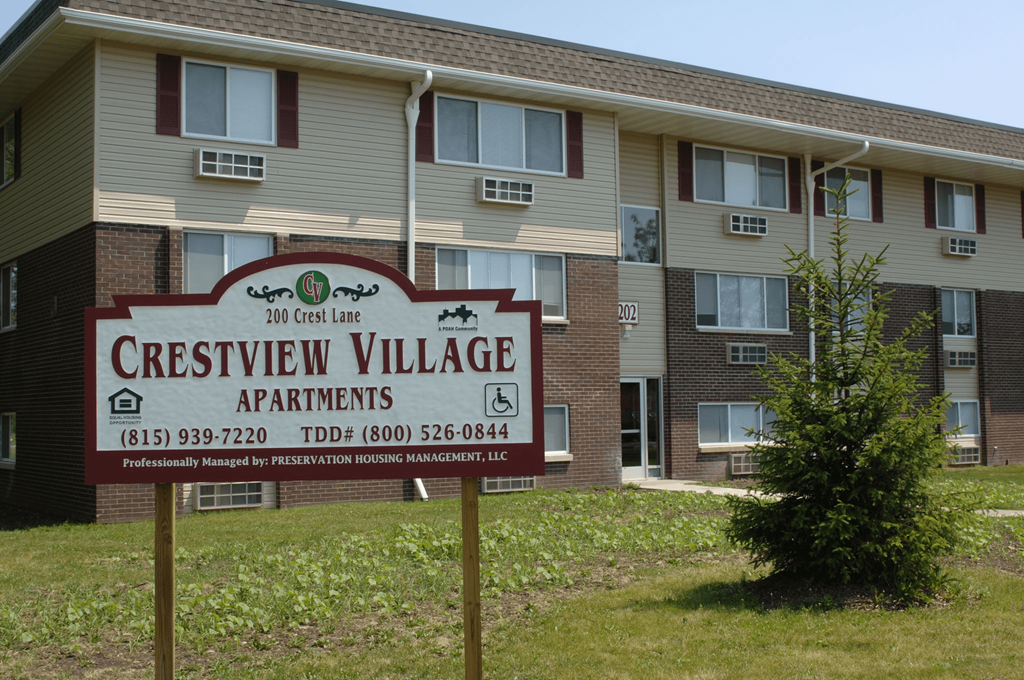 a sign in front of an apartment building