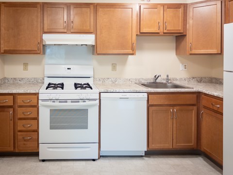 A kitchen with a white oven and a white dishwasher.