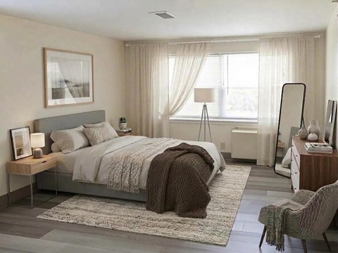 A bedroom with a large bed, a chair, and a nightstand.