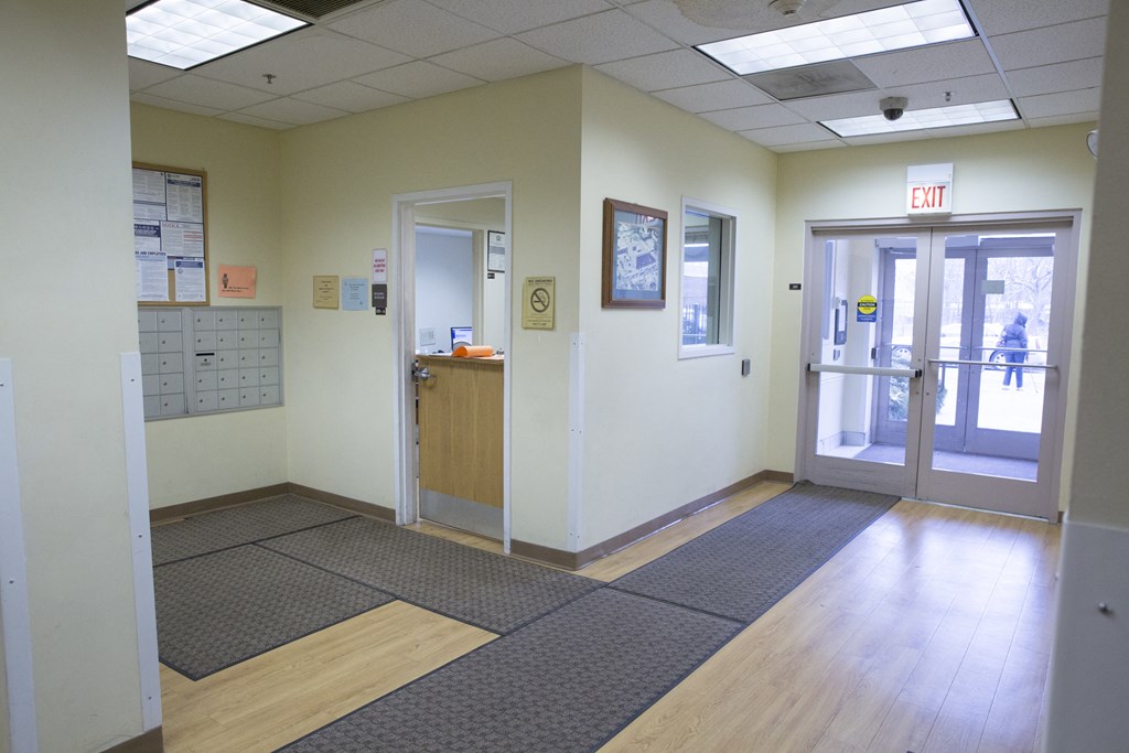 a view of a hallway in a hospital with doors and a counter