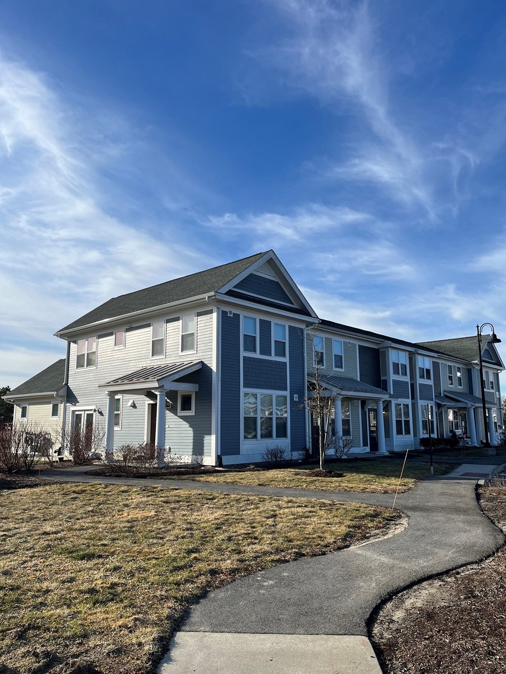 a blue house with a sidewalk in front of it