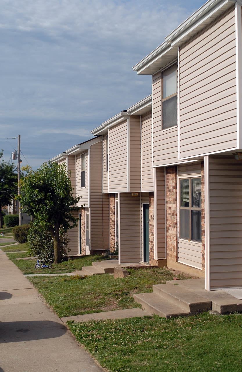 a row of houses with a sidewalk in front of them