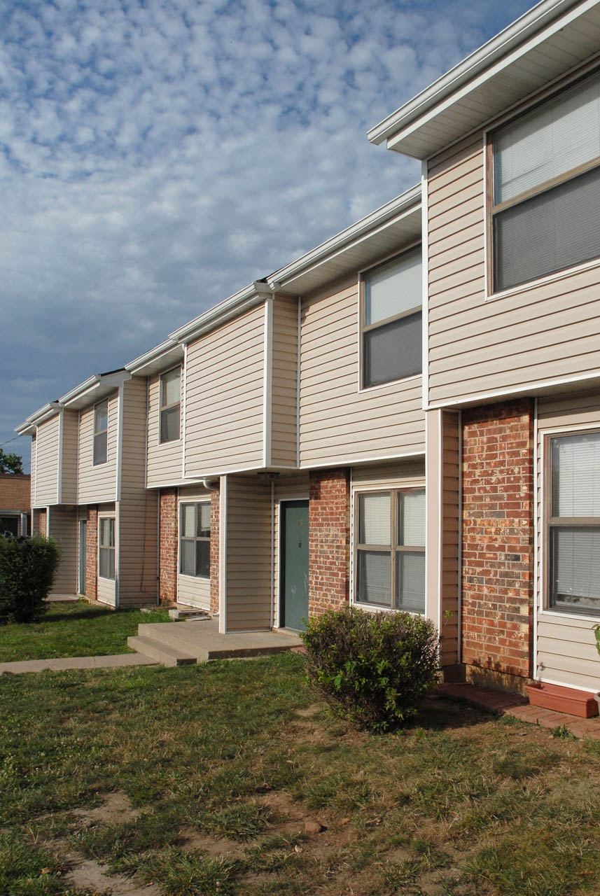 an apartment building with brick and white siding