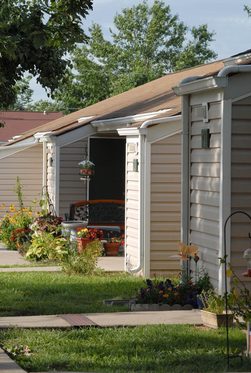 a small shed with a porch on the side of a house