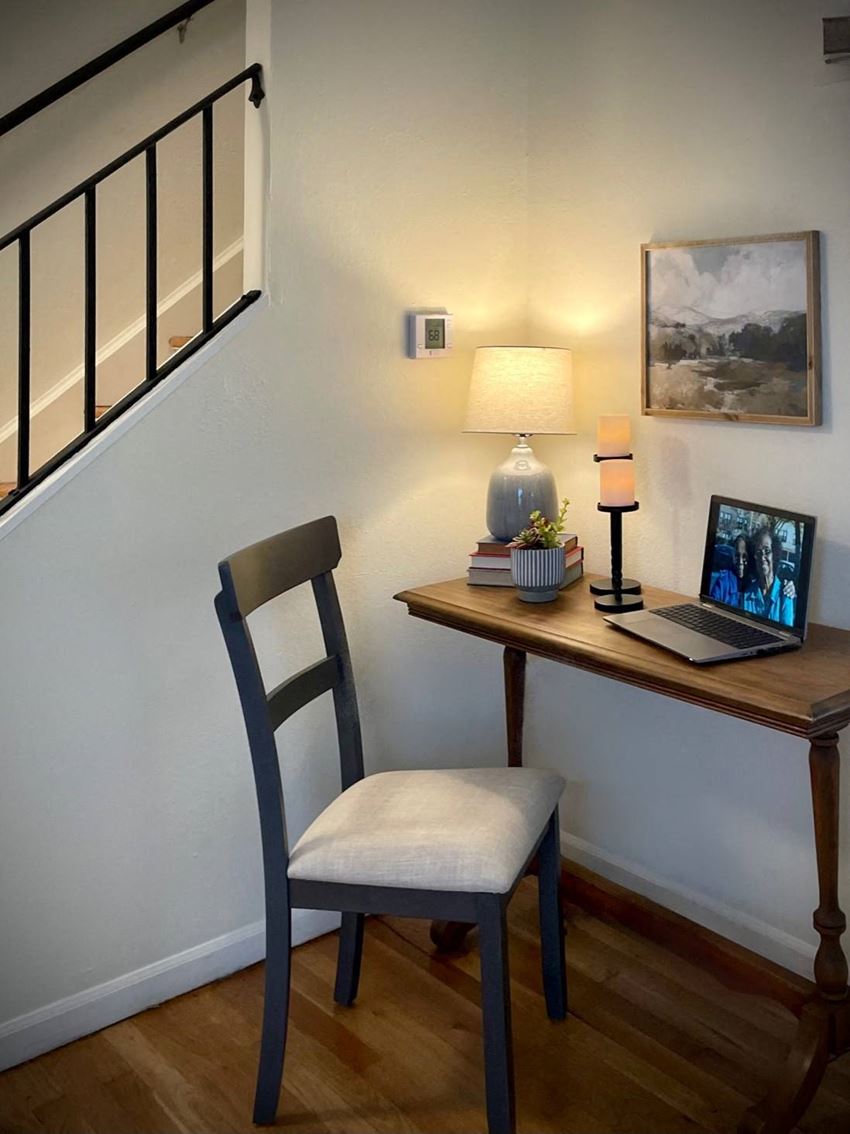a desk with a laptop and a lamp on top of it