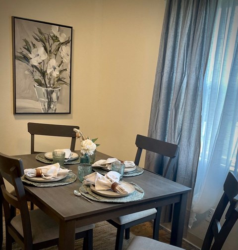 a dining room table with plates and a painting on the wall