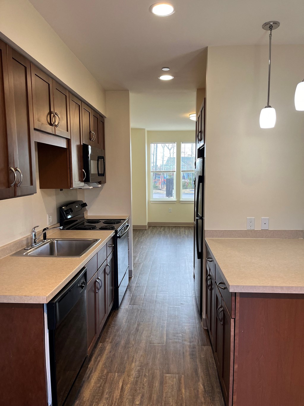 an empty kitchen with wood floors and wooden cabinets