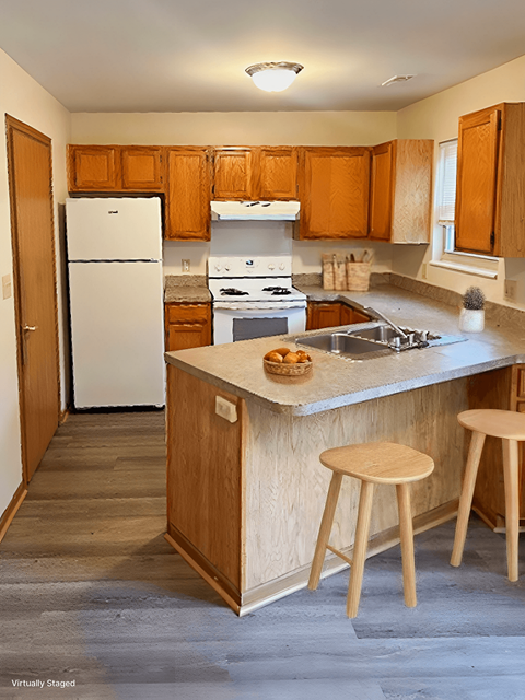 A kitchen with a white fridge and wooden cabinets.