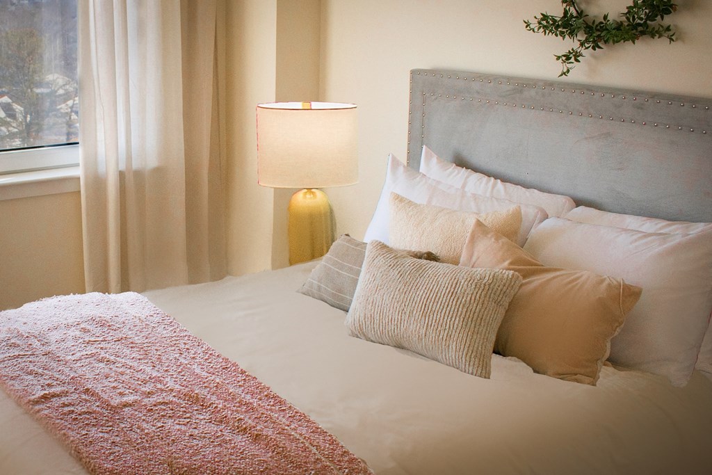 a bedroom with a bed and pillows and a lamp