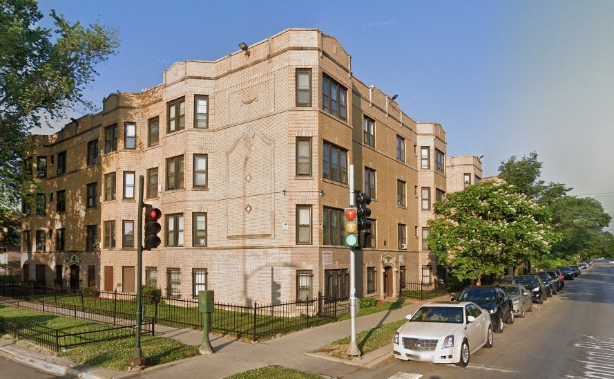a building on the corner of a street with cars parked in front of it
