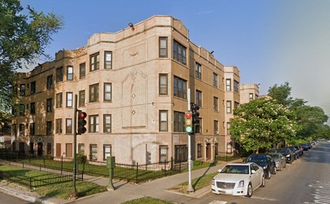 a building on the corner of a street with cars parked in front of it