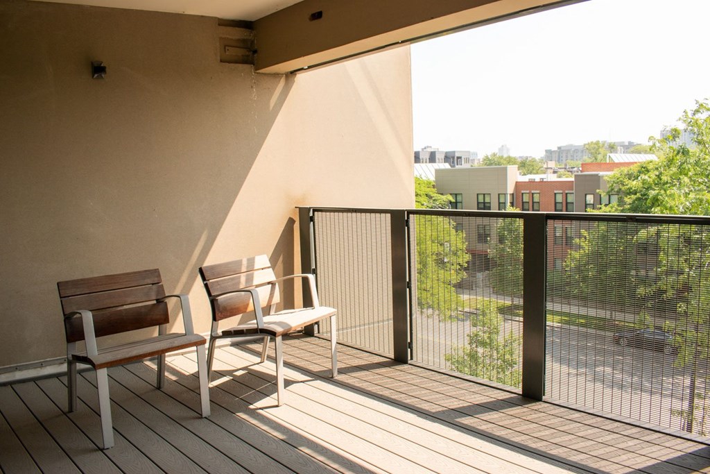 a balcony with two chairs and a view of the city