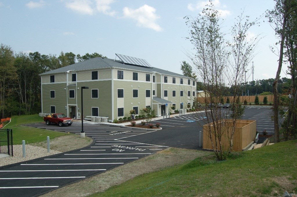 a building with solar panels on the roof and a parking lot