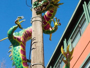 a dragon statue on top of a pole next to a building