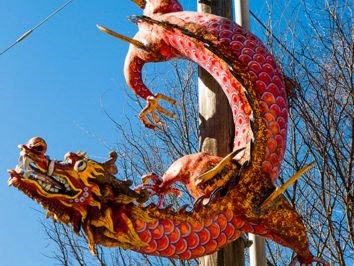 a dragon statue on the side of a pole