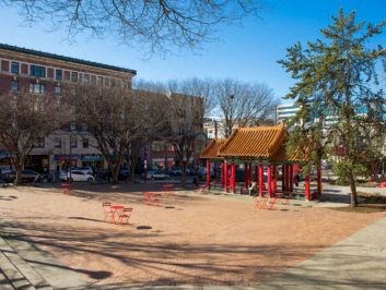a park with a pagoda and a building in the background