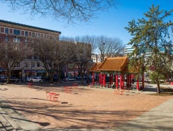 a park with a pagoda and a building in the background