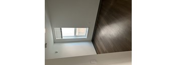 A room with a window and a wooden floor.