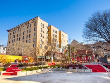 a park with three tall buildings in the background