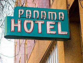 a green hotel sign on the side of a building