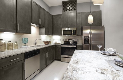 a kitchen with stainless steel appliances and marble counter tops